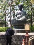 Japanese Man Praying to Buddha Statue at the Asakusa Temple, Tokyo, Japan